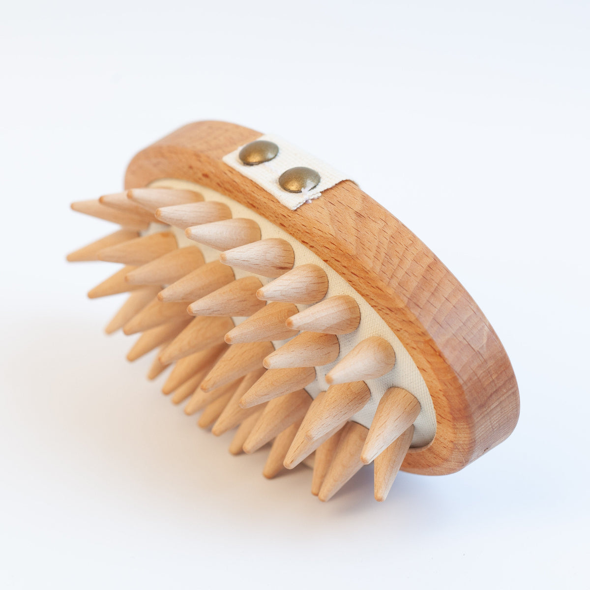 A wooden scalp massage brush with natural wood spikes and a curved wooden handle, photographed on a clean white background.